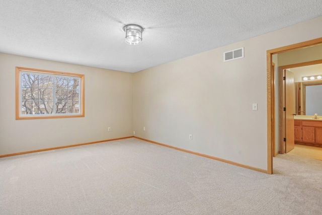 carpeted empty room with a textured ceiling