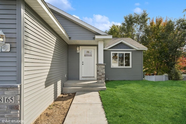 entrance to property with a lawn