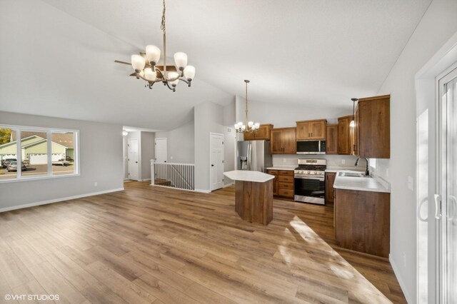 kitchen featuring sink, an inviting chandelier, a center island, hanging light fixtures, and stainless steel appliances