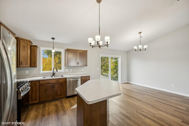 kitchen with stainless steel appliances, sink, a center island, and pendant lighting