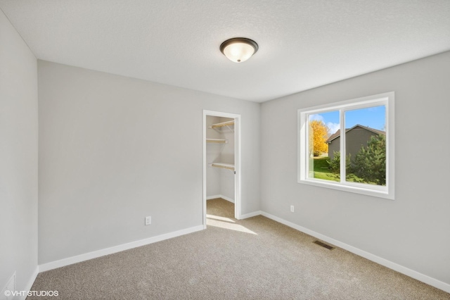 empty room with light carpet and a textured ceiling