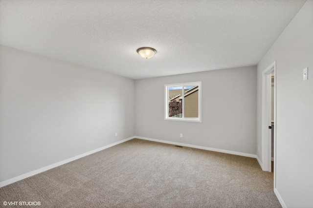 empty room featuring a textured ceiling and carpet flooring