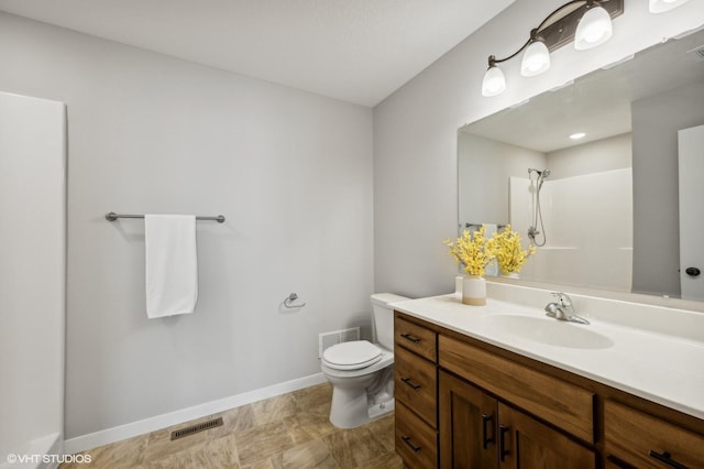 bathroom featuring walk in shower, vanity, and toilet