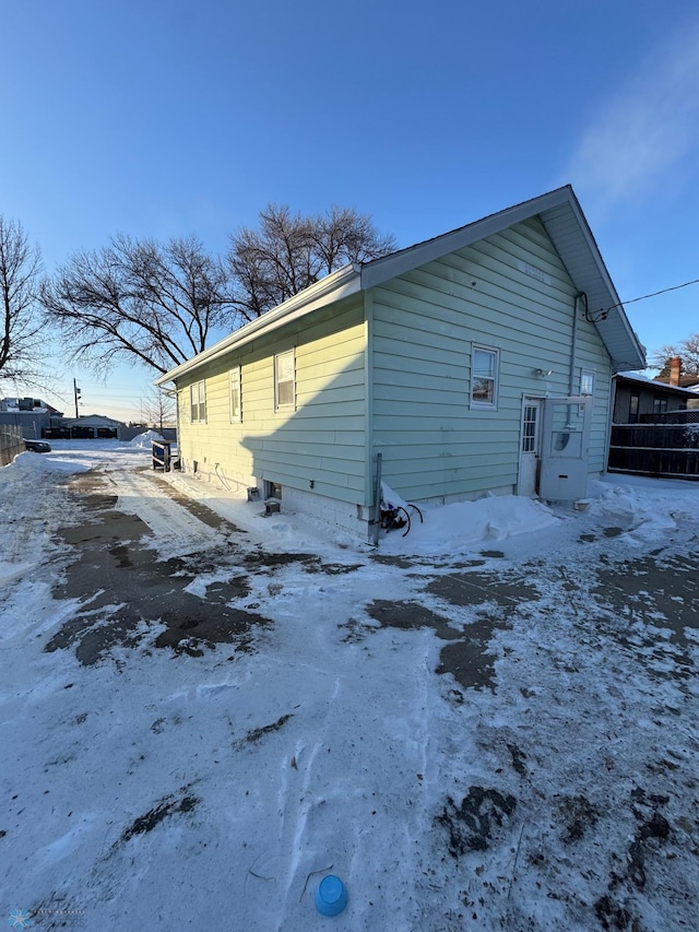 view of snow covered rear of property