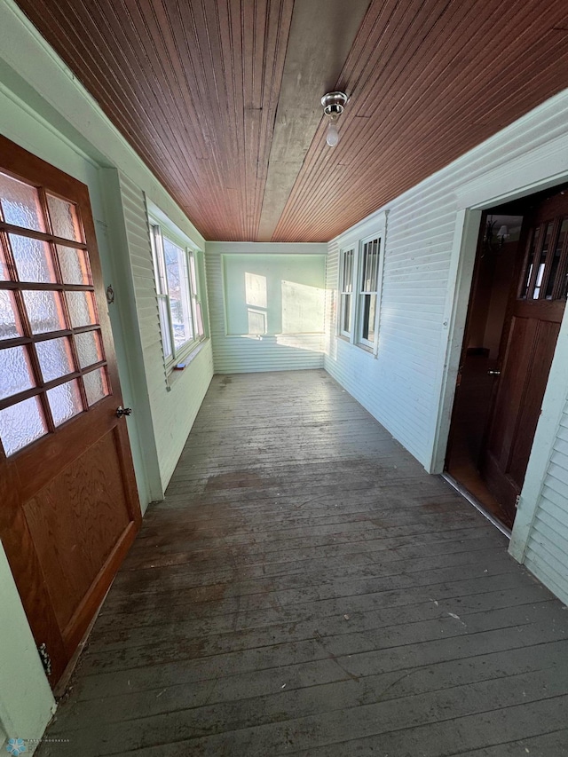 corridor with dark wood-type flooring and wooden ceiling