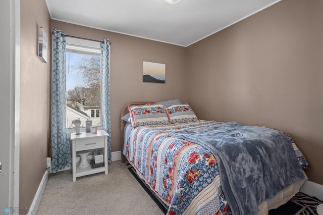 bedroom featuring baseboards and light colored carpet