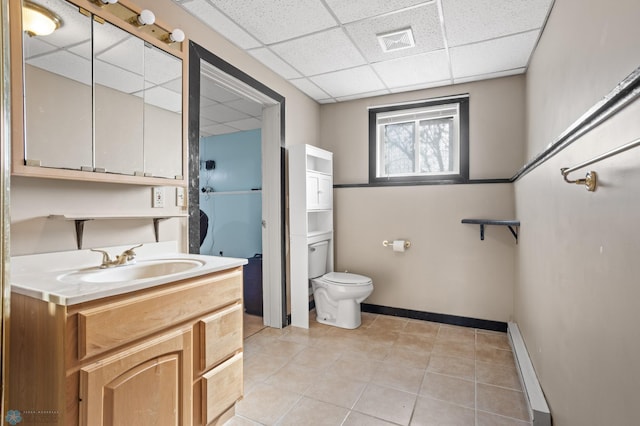 full bath featuring a drop ceiling, vanity, visible vents, baseboards, and baseboard heating