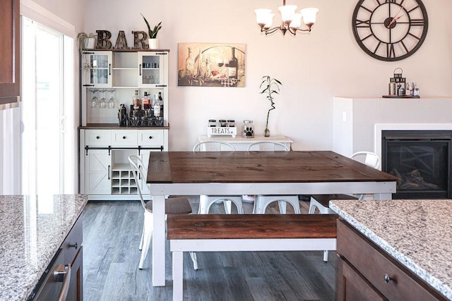 dining room with dark hardwood / wood-style floors and a notable chandelier