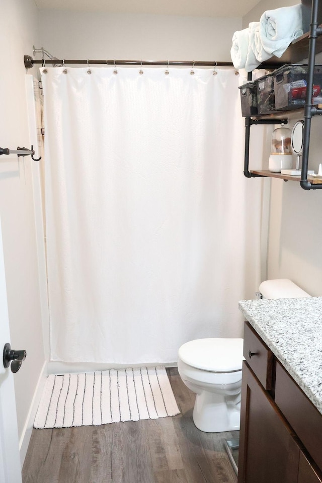 bathroom featuring wood-type flooring, vanity, and toilet