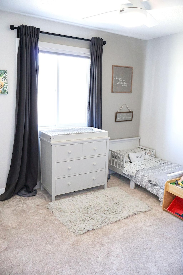 bedroom featuring light colored carpet and ceiling fan