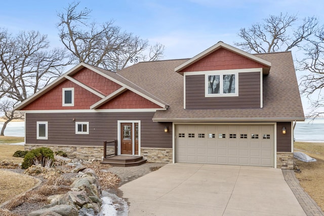 craftsman house featuring stone siding, concrete driveway, an attached garage, and a shingled roof