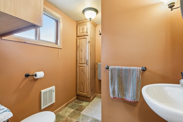 bathroom featuring visible vents, toilet, and baseboards