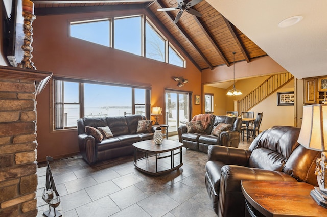 living area with wooden ceiling, plenty of natural light, ceiling fan with notable chandelier, and beam ceiling