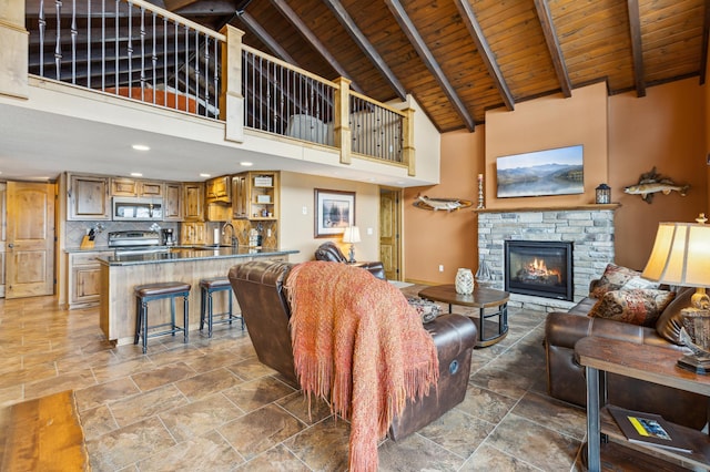 living room featuring a fireplace, beamed ceiling, wood ceiling, and high vaulted ceiling