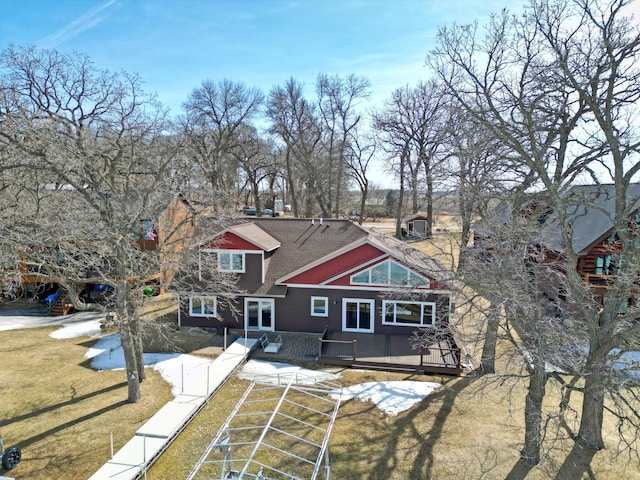 rear view of property with a yard, a fenced front yard, and roof with shingles