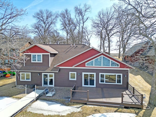 view of front facade featuring a deck and roof with shingles