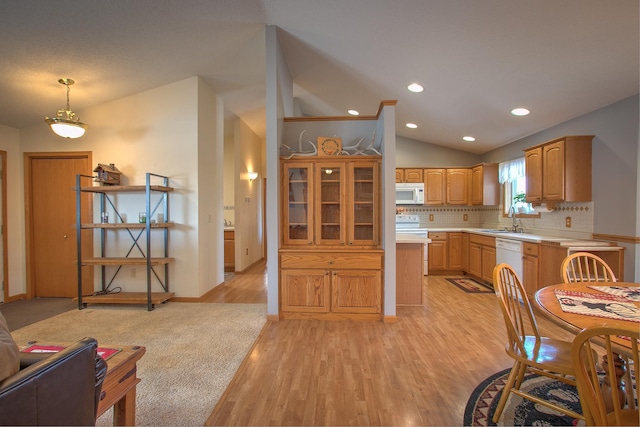 kitchen featuring lofted ceiling, sink, white appliances, light hardwood / wood-style flooring, and decorative light fixtures