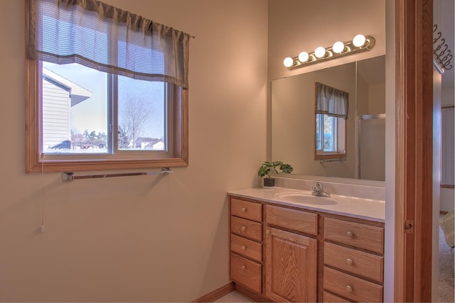 bathroom with a shower with door and vanity