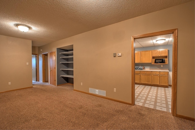 carpeted spare room with a textured ceiling