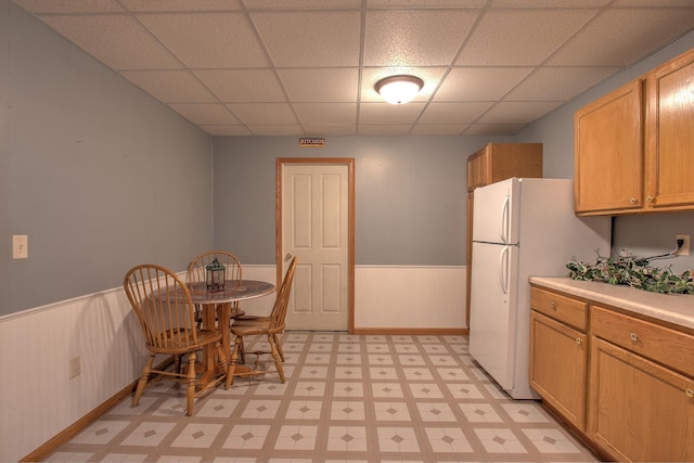 kitchen with a paneled ceiling and white fridge