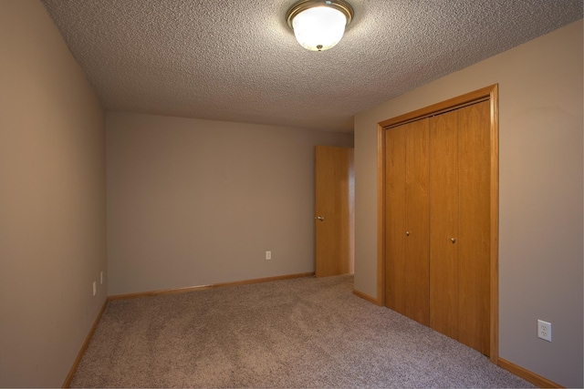 unfurnished bedroom with carpet floors, a textured ceiling, and a closet