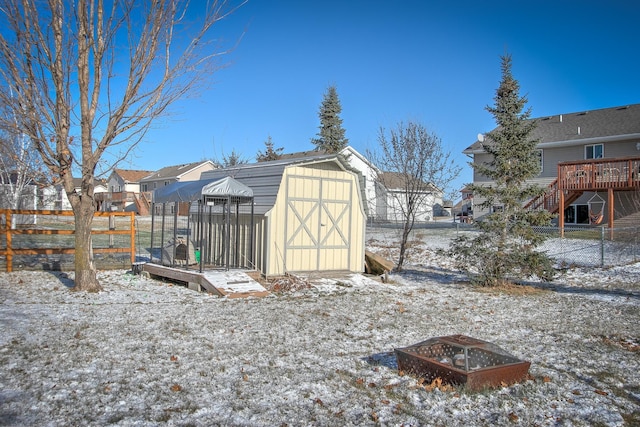 yard layered in snow featuring a fire pit and a storage shed