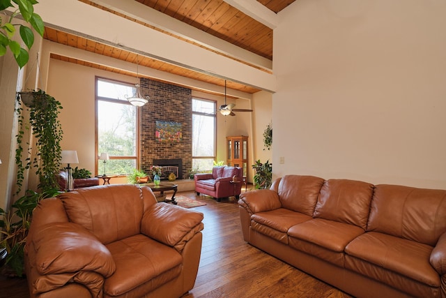 living room featuring wood ceiling, ceiling fan, hardwood / wood-style floors, beam ceiling, and a brick fireplace