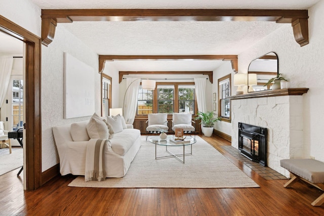 living room with dark hardwood / wood-style floors, beam ceiling, and a textured ceiling