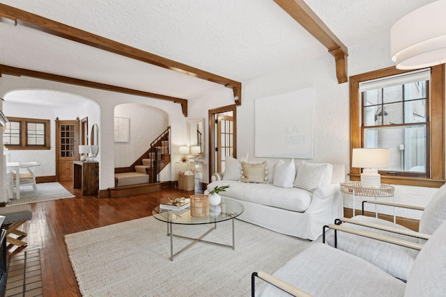 living room featuring dark hardwood / wood-style floors, a textured ceiling, and beam ceiling