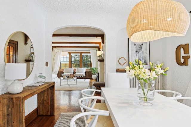 dining space with dark hardwood / wood-style floors and beam ceiling