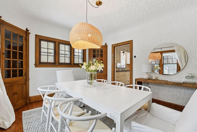 dining space featuring dark hardwood / wood-style flooring and a textured ceiling