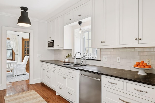 kitchen featuring white cabinetry, ornamental molding, appliances with stainless steel finishes, and sink