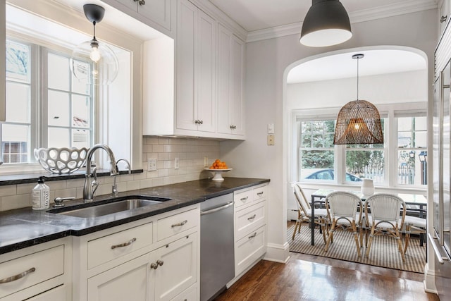 kitchen with hanging light fixtures, sink, stainless steel dishwasher, and white cabinets