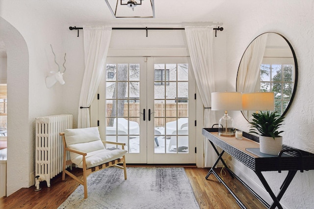 doorway to outside featuring hardwood / wood-style flooring, radiator heating unit, and french doors