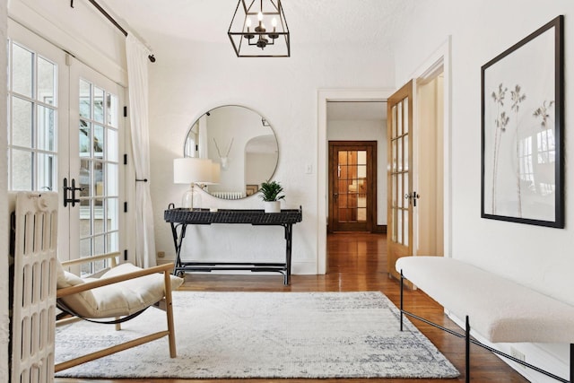 interior space with a notable chandelier, hardwood / wood-style flooring, radiator, and french doors