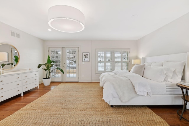 bedroom with dark hardwood / wood-style floors, access to exterior, and french doors