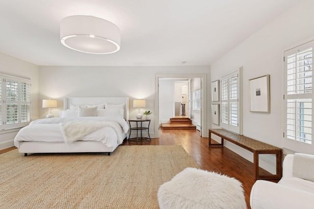 bedroom with multiple windows and hardwood / wood-style floors