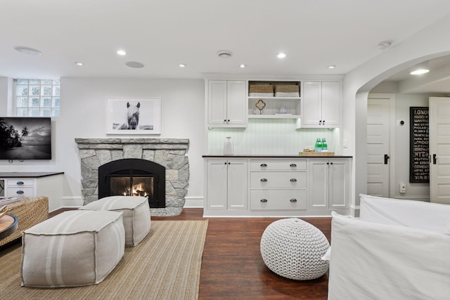 living room featuring a stone fireplace and hardwood / wood-style floors