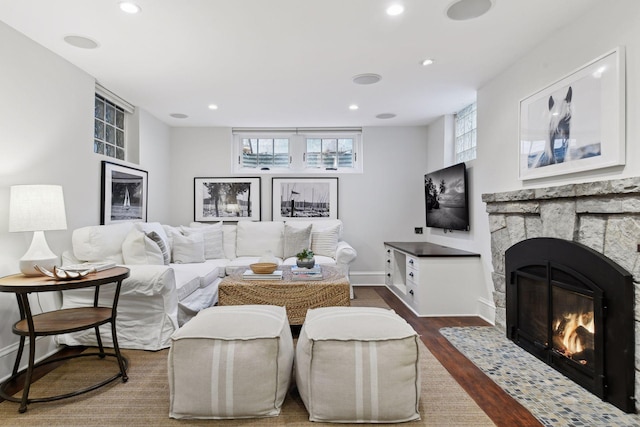 living room with dark wood-type flooring and a fireplace