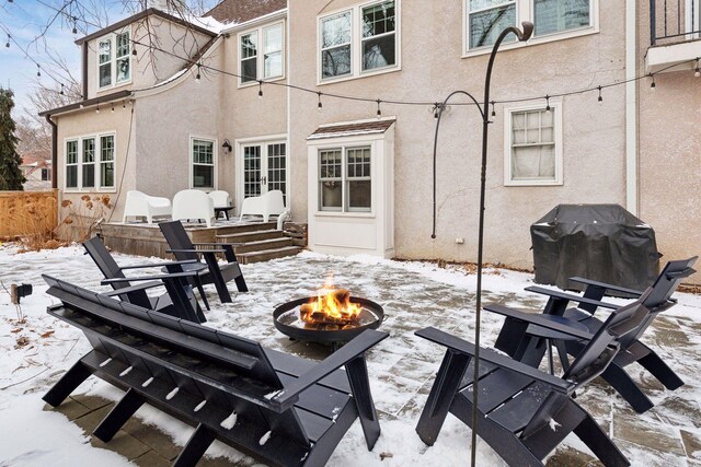 snow covered rear of property featuring an outdoor fire pit