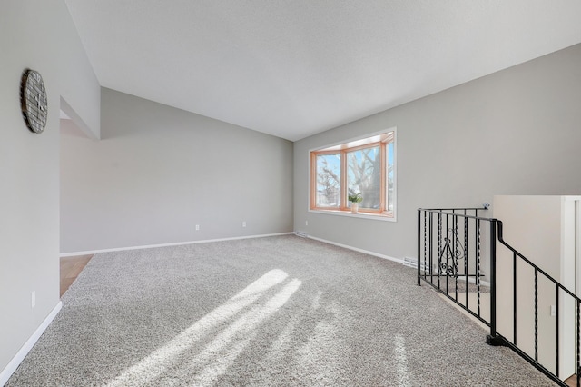 unfurnished room with light carpet and lofted ceiling