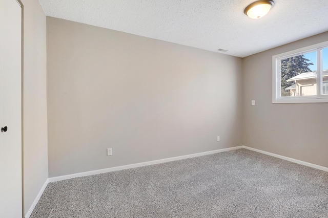 spare room featuring carpet floors and a textured ceiling