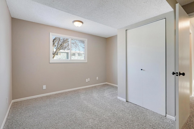 unfurnished bedroom featuring carpet floors, a closet, and a textured ceiling