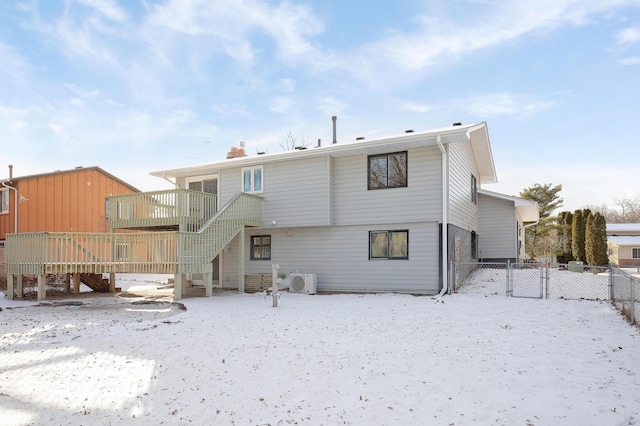 snow covered property featuring a wooden deck and ac unit