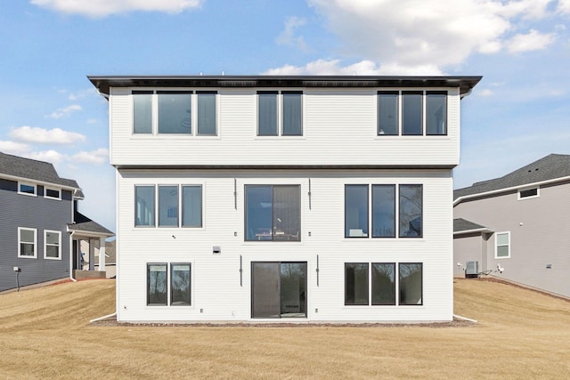 rear view of property with a lawn and central air condition unit