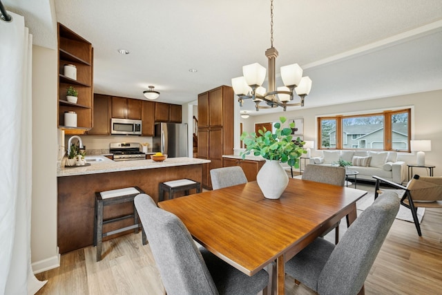 dining room with light wood-type flooring and a notable chandelier