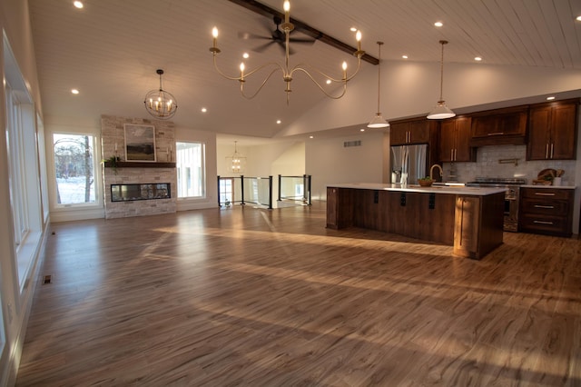 kitchen with an inviting chandelier, decorative light fixtures, a large island with sink, appliances with stainless steel finishes, and dark hardwood / wood-style floors