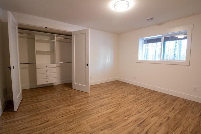 unfurnished bedroom featuring wood-type flooring and a closet