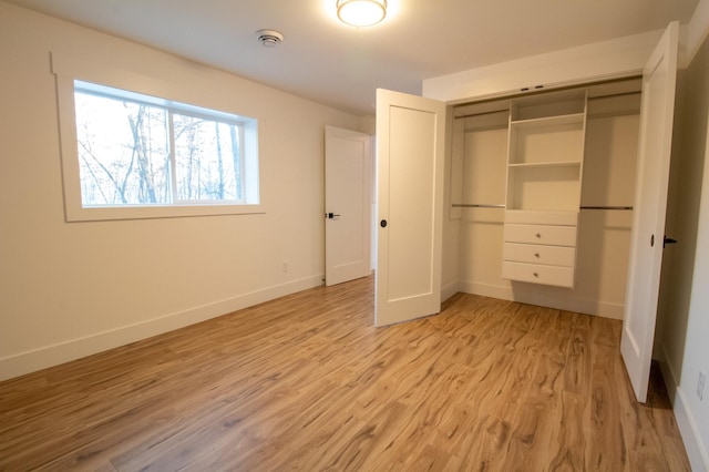 unfurnished bedroom featuring light hardwood / wood-style floors and a closet