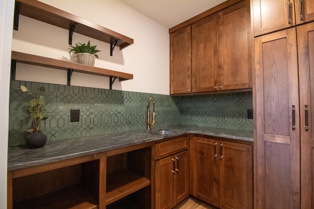 kitchen featuring tasteful backsplash, sink, and dark stone countertops